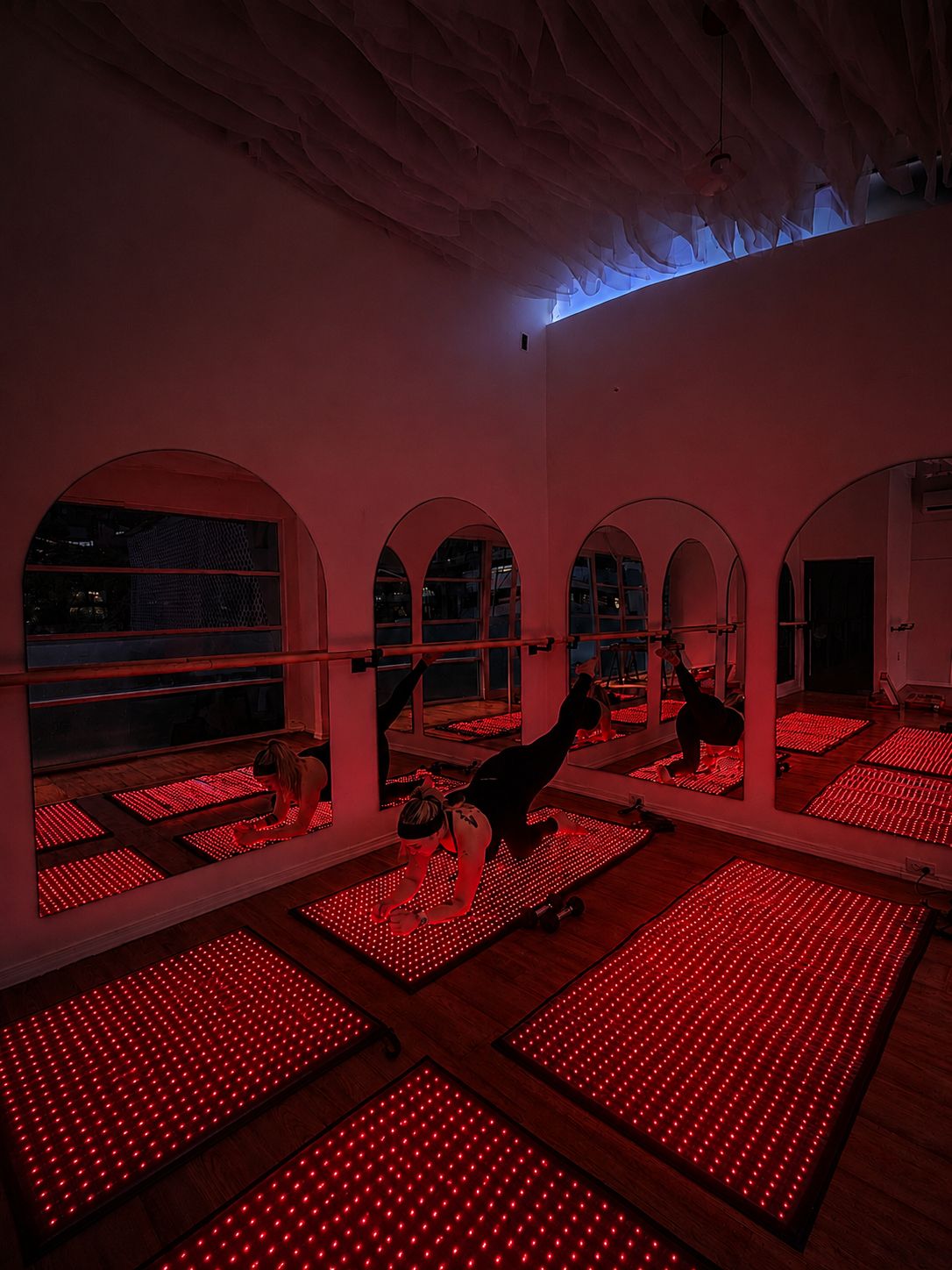 Clase de Pilates bajo luz roja en el estudio